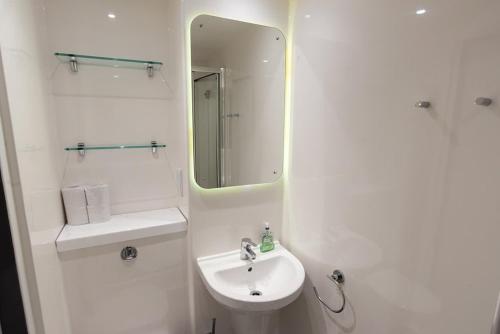 a white bathroom with a sink and a mirror at Ensuite Single Room in Central Coventry in Coventry