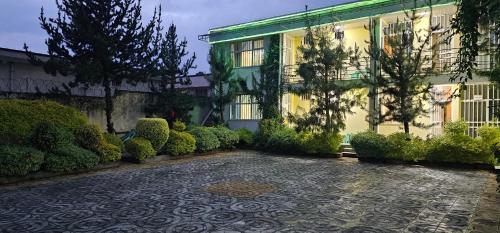 a courtyard of a building with a stone driveway at Avi-Pension in Addis Ababa