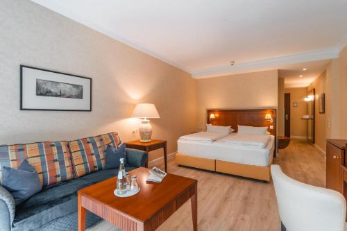 a hotel room with a bed and a couch at Grand Hotel Binz in Binz