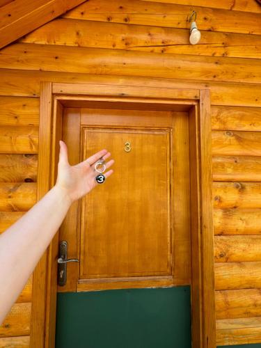 a person opening a wooden door in a room at Gusinje View in Gusinje