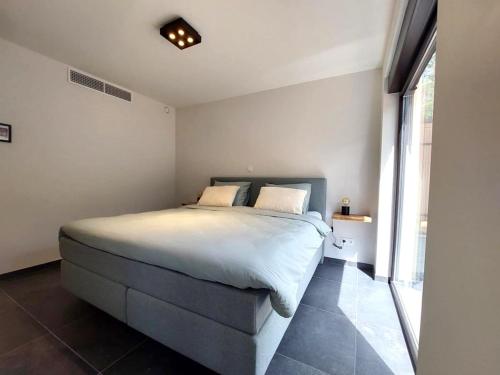 a bedroom with a bed and a large window at Vakantiewoning in 't groen-Lille in Lille