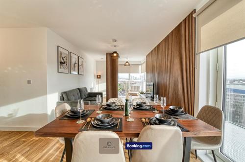 a dining room with a large wooden table and chairs at 3 Bedroom Apartment By Paul & Malin Properties Short Lets & Serviced Accommodation Stretford With Gym Access in Manchester