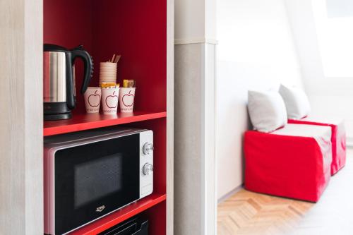a microwave on a red shelf in a room at Omena Hotel Turku Kauppiaskatu in Turku