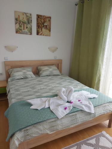 a bed with two white towels on it at Villa Lyudmila in Utjeha