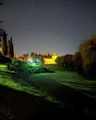 a green field at night with a castle in the background at CASA VASARI Holiday Suites TUSCANY in Lucignano