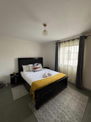 Un dormitorio con una cama grande con una manta amarilla. en Nyayo Estate Embakasi near Airport and Sgr, en Nairobi