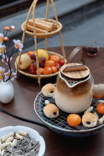 a table with a bowl of mushrooms and a bowl of fruit at Xingshengjiu Courtyard Hotel Pingyao in Pingyao