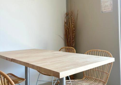 a wooden table with chairs in a room at Hôtel Le Carnon in Carnon-Plage