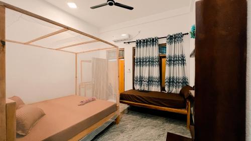 une chambre avec deux lits et un ventilateur de plafond dans l'établissement Perera Hotel & Restaurant, à Baie d'Arugam