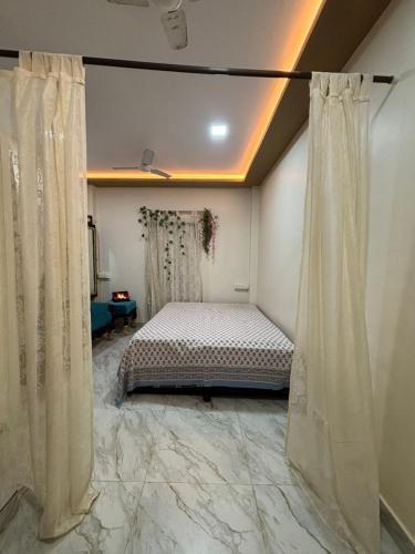 a bedroom with a bed in a room with curtains at Sattva Stays in Mumbai