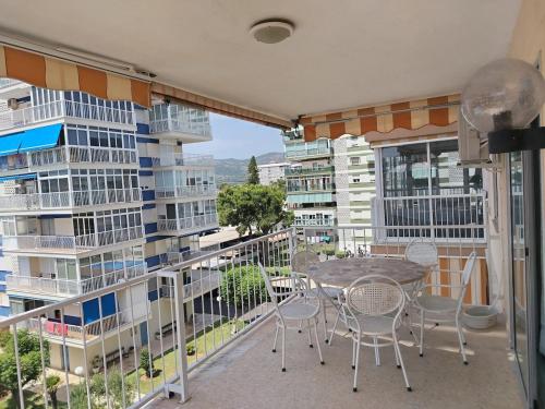 a balcony with a table and chairs and buildings at Apartamento en El Torreón, parking y WiFi-fibra in Benicàssim