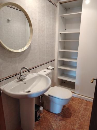 a bathroom with a sink and a toilet and a mirror at Apartamento en El Torreón, parking y WiFi-fibra in Benicàssim