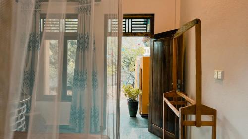 une pièce avec une fenêtre et un vase avec une plante dans l'établissement Perera Hotel & Restaurant, à Baie d'Arugam