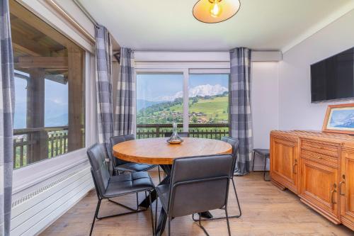 une salle à manger avec une table et des chaises et une grande fenêtre dans l'établissement Chalet Nessa, à Combloux
