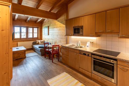 a kitchen with wooden cabinets and a table and a couch at Madlhof in Himmelreich