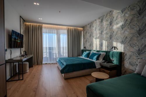 a hotel room with a bed and a couch at Hotel Majestic in Durrës