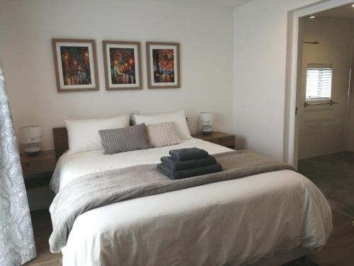 a bedroom with a bed with two pictures on the wall at Skye in Paternoster