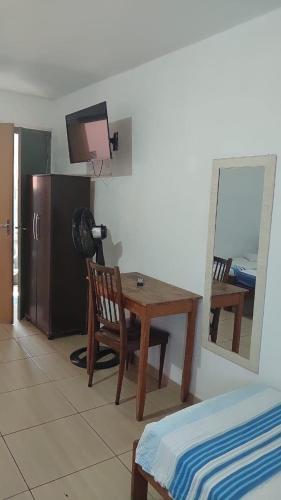 a room with a table and a chair and a mirror at Hotel JF2 in Pirassununga