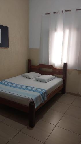 a bed sitting in a room with a window at Hotel JF2 in Pirassununga