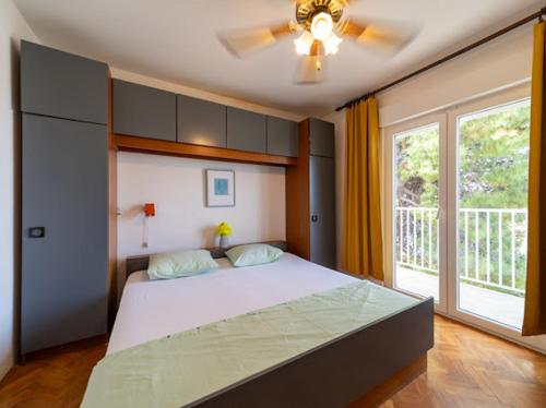 a bedroom with a large bed and a window at Fia 70s Beach Apartment in Rab
