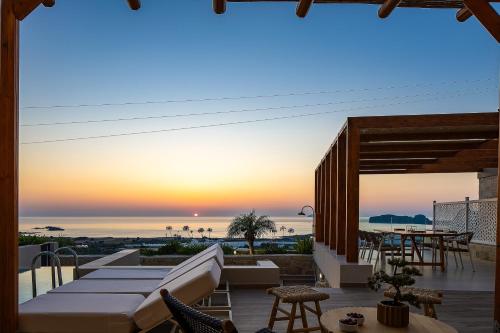 a patio with a view of the ocean at sunset at Falasarna Luxury Villas I Private "heated" pools, ideal for groups in Falasarna