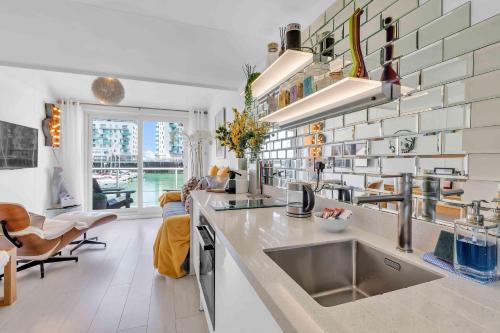 a kitchen with a sink and a living room at On the Water 7 Free Parking By My Getaways in Brighton & Hove