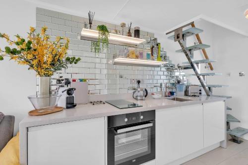a kitchen with white cabinets and a counter top at On the Water 7 Free Parking By My Getaways in Brighton & Hove
