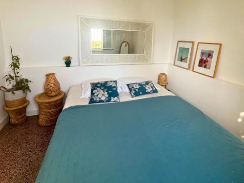 a bedroom with a blue bed with two pillows at Santa Margarita in Saint-Raphaël
