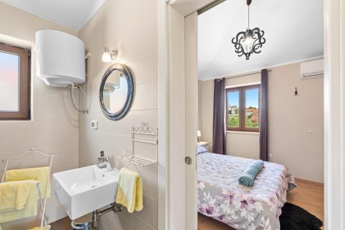 a bedroom with a bed and a sink and a mirror at Villa Anteva in Poreč