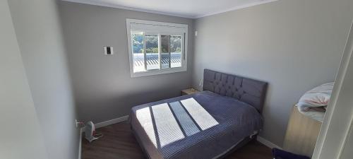 Un dormitorio pequeño con una cama y una ventana. en Residência familiar, en Erechim