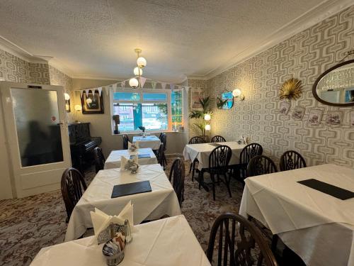 a restaurant with tables and chairs with white tablecloths at The Scala Hotel in Blackpool
