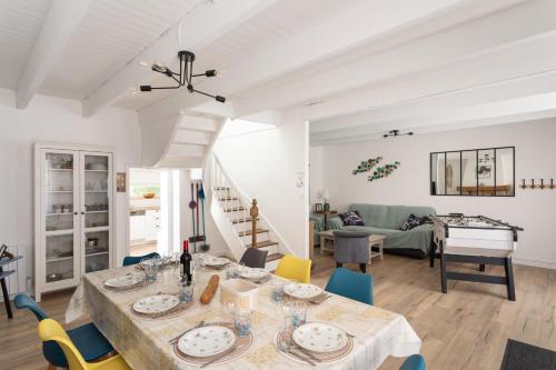 Un comedor y una sala de estar con mesa y sillas. en Ti Daouzek - Proche plage des Sables-dOr, en Plurien