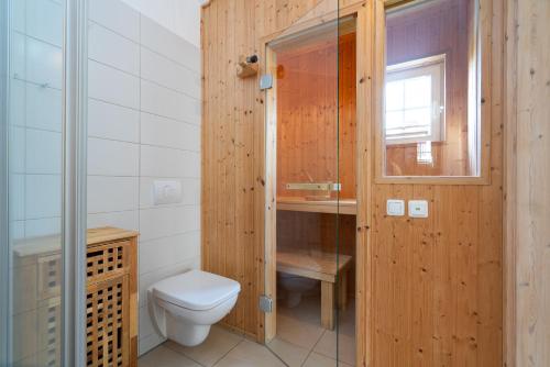 a wooden bathroom with a toilet and a window at Strandpark Sierksdorf H051 in Sierksdorf
