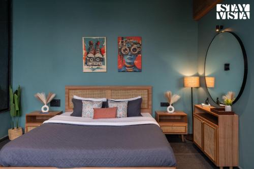 a bedroom with a bed and a blue wall at StayVista at The Solitaire Home with BBQ, Lawn, AC in Dhamni