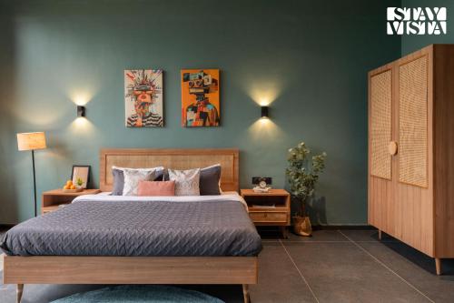 a bedroom with a bed and two paintings on the wall at StayVista at The Solitaire Home with BBQ, Lawn, AC in Dhamni