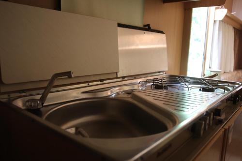 a kitchen with a sink and a stove at Full-Service Caravan in Albertslund