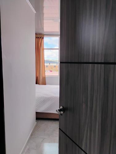 a door leading to a bedroom with a bed at Hotel Iraca in Aquitania