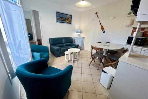 un salon avec des chaises bleues et une table dans l'établissement Nice and quiet appartment only 2 steps away from the harbour of St Martin, à Saint-Martin-de-Ré