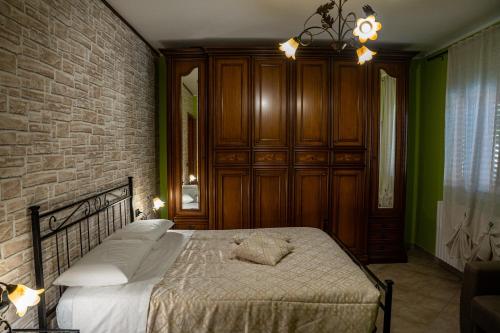 a bedroom with a bed and a brick wall at Villa Marika in Dragonetti