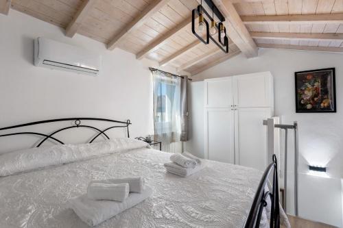 a white bedroom with a bed with towels on it at Casa Mary Vicino a Camaiore in Camaiore