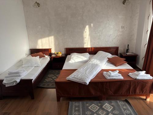 two beds in a bedroom with towels on them at Rusticanna RESTAURANT & SPA in Ranca