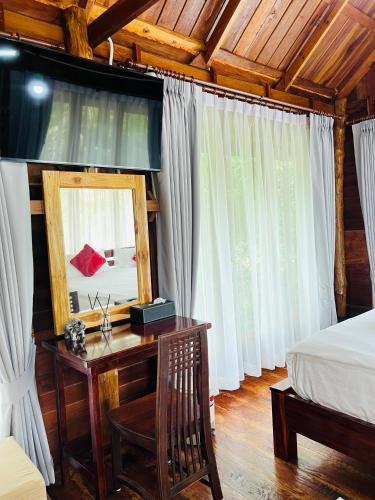a bedroom with a desk with a mirror and a bed at บ้านสวนแก้วคำแพง Baan Suan Kaew Khampaeng in Udon Thani