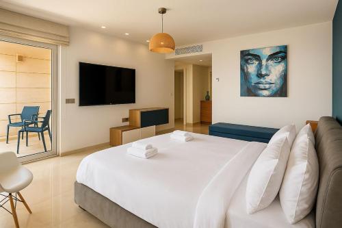 a bedroom with a large white bed and a couch at Magnificent 3BR-2BA in Marina Herzliya w Pool in Herzliyya B