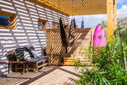 a house with a deck with two chairs and an umbrella at Aloha Studio in La Oliva