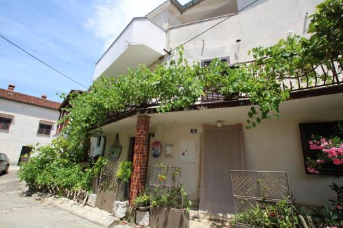 une maison avec un arbre sur son côté dans l'établissement Apartments Sonnenblume, à Funtana