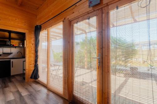a room with sliding glass doors in a wooden house at Aloha Studio in La Oliva