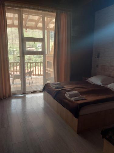 a bedroom with a bed and a large window at Come & Rest in Stepantsminda