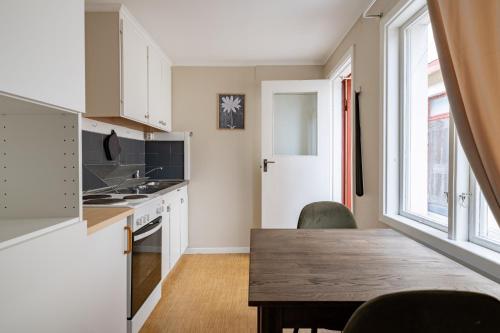a kitchen with a wooden table and a dining room at Cozy studio in separate building in Visby