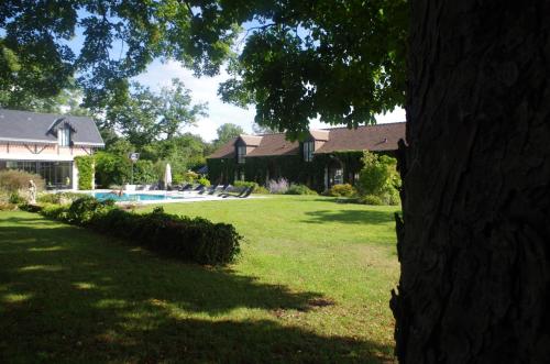 a yard with a house and a swimming pool at Manoir des Logis in Yvré-lʼÉvêque