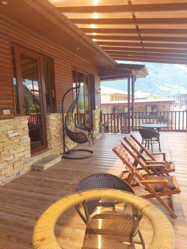 a deck with chairs and tables on a house at Come & Rest in Stepantsminda